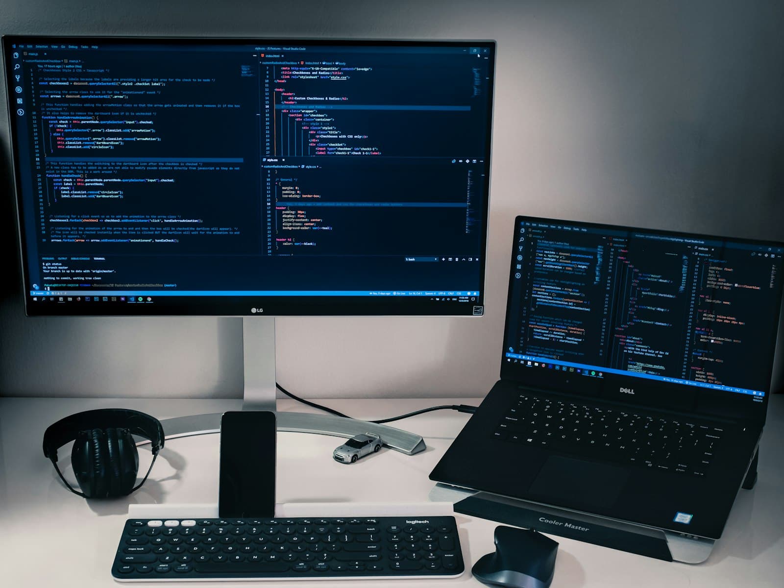 Laptop and monitor showing code on a dark desk setup